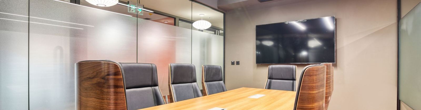 A conference room with a long table and glass walls