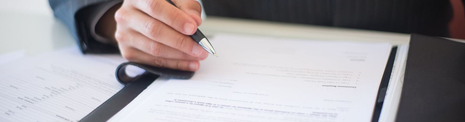 Documents and a pen laid out on a desk