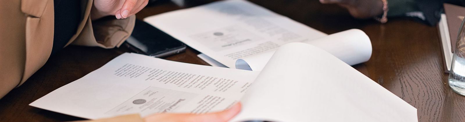 Paperwork and laptops on a table during a working meeting