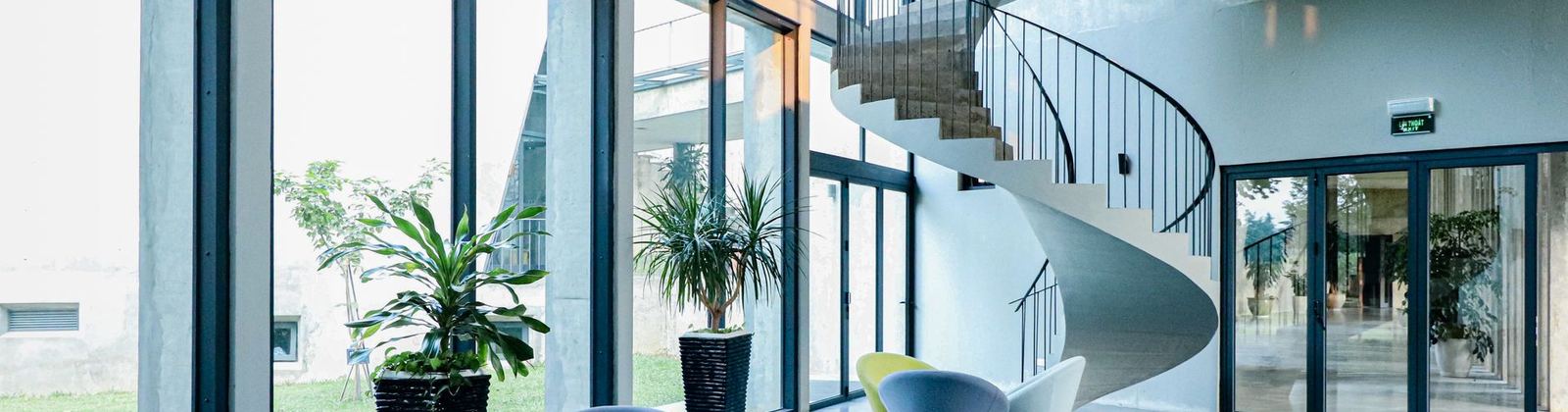 An office lobby with a spiral staircase and full height windows