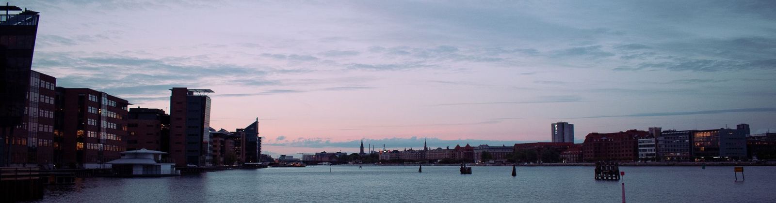 A city skyline across the water at dusk
