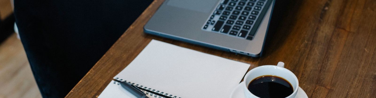 A laptop and notebook on a working desk