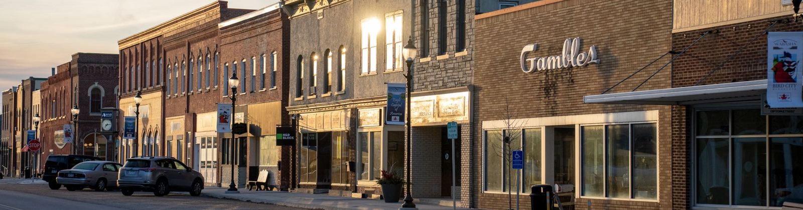 Storefronts lit at dusk along a small town main street